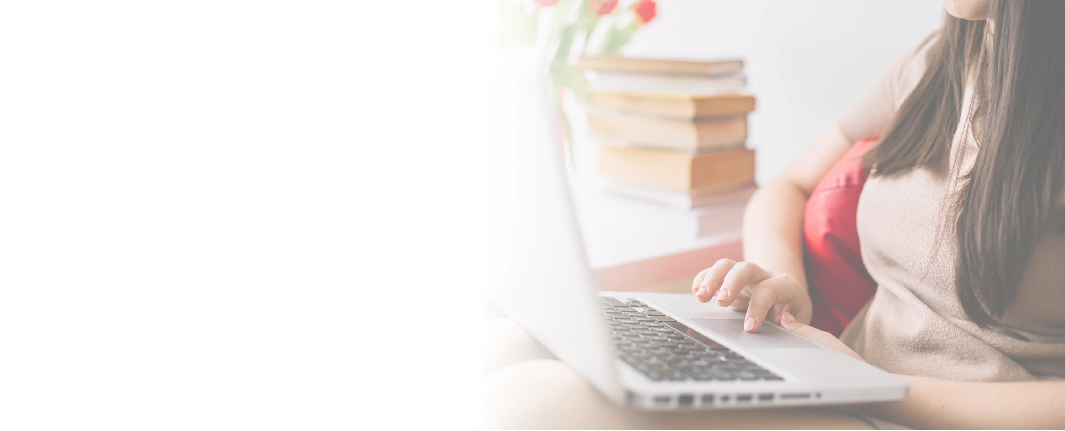 Persona trabajando en laptop con libros